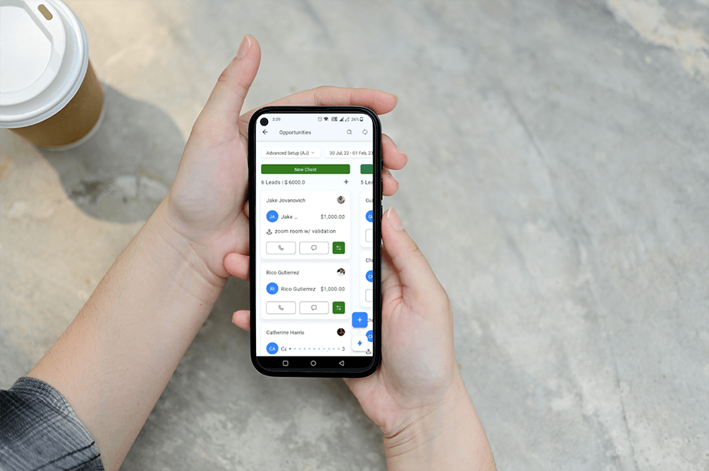 A person holding a smartphone displaying a CRM application screen