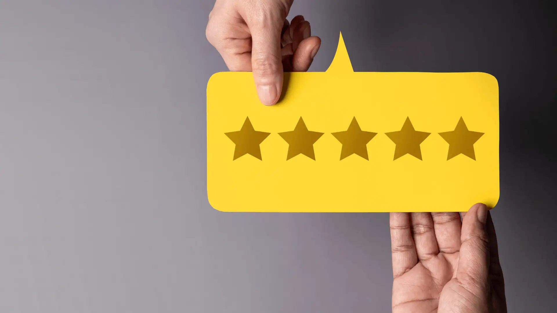 A yellow speech bubble with a five-star rating held by two hands, symbolizing customer trust and the credibility built through reviews and testimonials.