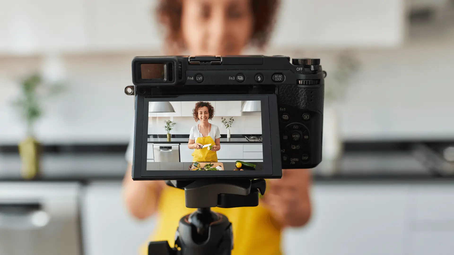 A camera recording a woman creating video content in a kitchen, symbolizing the power of video and content marketing for business growth and engaging online audiences.