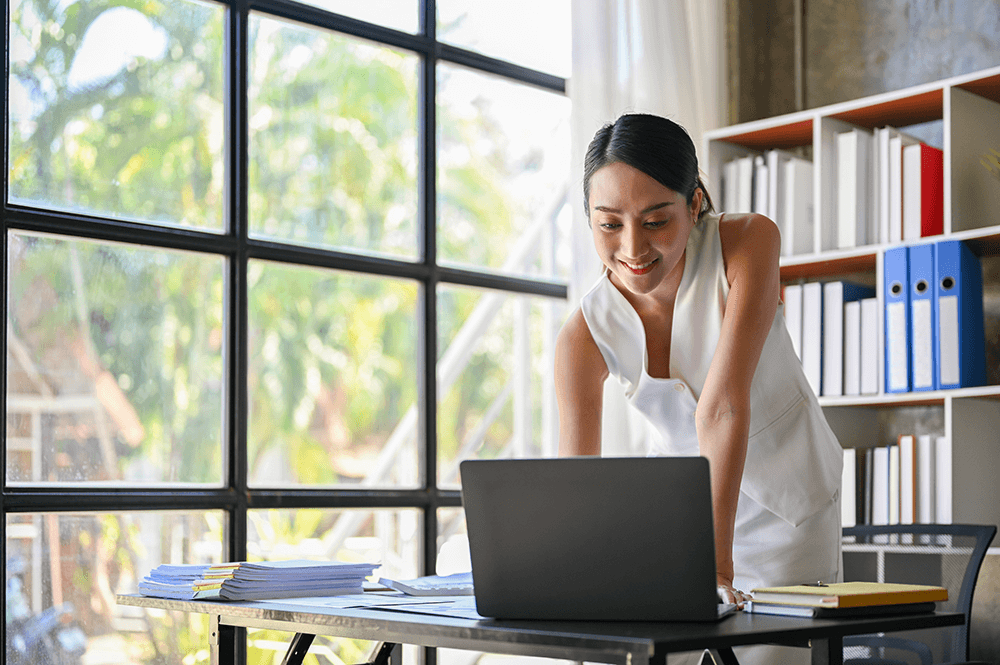 A marketing strategist in a bright office reviewing a digital campaign on a laptop. Represents high-quality service business marketing and dedicated consultant support for local SEO services.