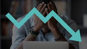A frustrated business owner with his head in his hands behind a laptop, overlaid with a declining teal arrow graphic, symbolizing the lack of ROI from a poor marketing agency partnership.